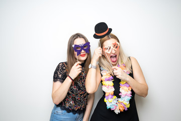 two girls posing party props photo booth white background studio drunk happy laugh