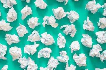 Crumpled sheets of white paper ball. A lot of trash paper. Turquoise, mint background