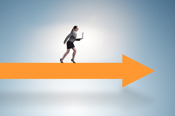 Obraz premium Businesswoman walking on arrow sign