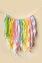 Ragged patches hang on the wall in the form of a garland. Rainbow made from pieces of cloth.