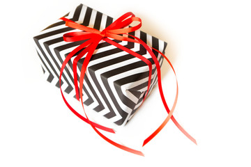 Gift box. Black white zigzag. White background, red ribbon. - Powered by Adobe