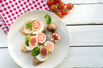 fresh ripe sliced fig on toast bread mozzarella cheese Italian crostini dish light lunch starter