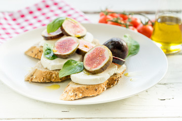 fresh ripe sliced fig on toast bread mozzarella cheese Italian crostini dish light lunch starter