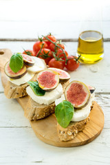 fresh ripe sliced fig on toast bread mozzarella cheese Italian crostini dish light lunch starter