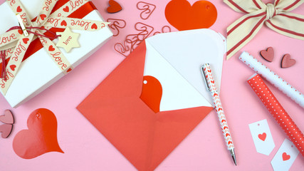 Happy Valentine's Day overhead flat lay wrapping gift and writing cards. 