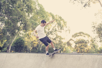 man practicing radical skate board jumping and enjoying tricks and stunts in concrete half pipe skating track in sport and healthy lifestyle