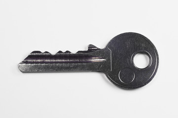 Steel key to the door lock, large magnification on a white background