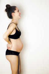 Obraz premium beautiful happy pregnant young woman in black lingerie - side view