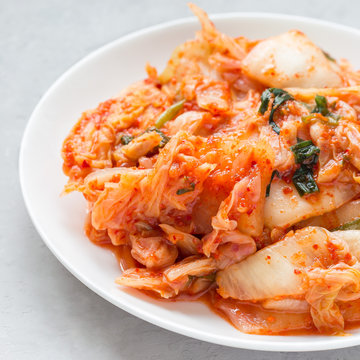 Kimchi cabbage. Korean appetizer on a white plate, square