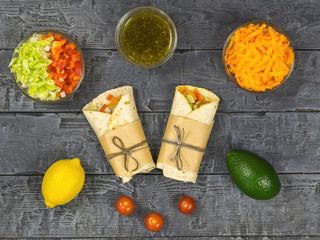 Cabbage, carrot, pepper, avocado, tomatoes in pita bread on a rustic table. Vegetarian food.