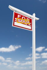 Left Facing Sold For Sale Real Estate Sign on a Blue Sky with Clouds.