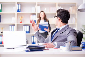 Businessman asking for paperwork from his assistant secretary