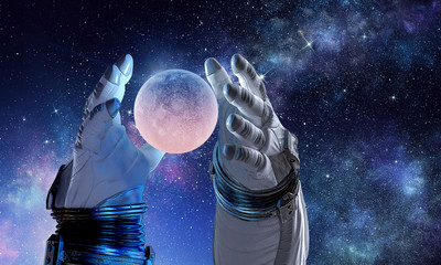 Fototapeta na wymiar Moon planet in spaceman hand. Mixed media