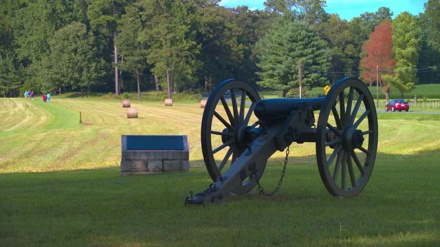 Cold Harbor National American Civil War Battlefield featuring a Confederate Field Artillery Cannon in the foreground and People Visiting the Historical Site in the background