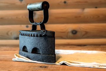 Flatiron old iron lying on a wooden table with a cloth, the Russian iron 19th century