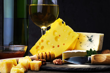 Cheese with wine and honey on a dark wooden table. Close-up.