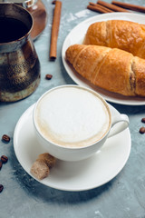Cup of coffee with croissants on the rustic wooden background. Selective focus. Shallow depth of field.