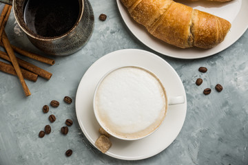 Cup of coffee with croissants on the rustic wooden background. Selective focus. Shallow depth of field.