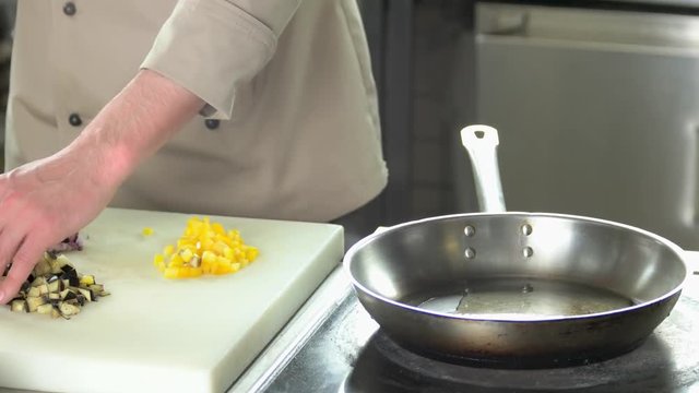 Chef pouring oil into pan. Cooking in the kitchen.