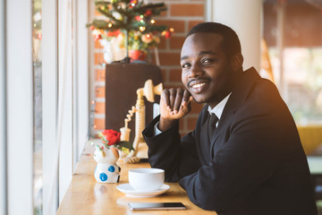 Cheerful african american businessman drinking coffee in cafe.