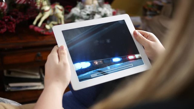 Woman watching action movie on her tablet device at home