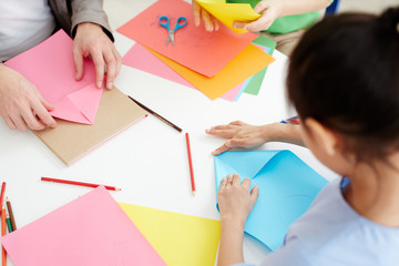 Secondary school learners using pink and blue paper while making origami