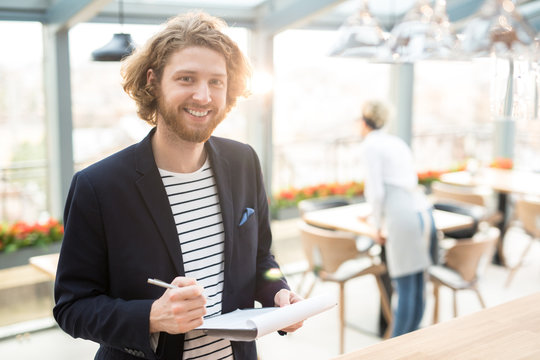 Happy businessman with document making notes about new restaurant