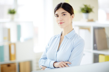 Serene young specialist or office worker with crossed arms looking at camera