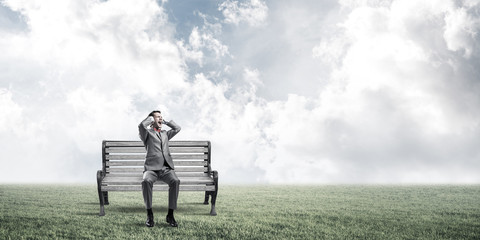 Young man in suit in park dont want to hear anything