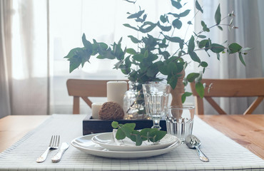 Table setting with branches of eucalyptus in light shades.