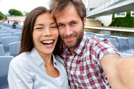Cheerful Couple Sitting In Tourist Boat