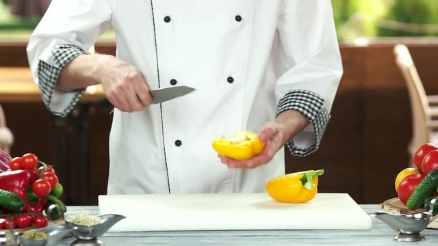 Chef cutting a vegetable. Yellow bell pepper.