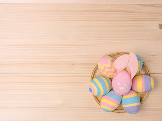 Painted Easter eggs in basket on wooden table, concept for Easter