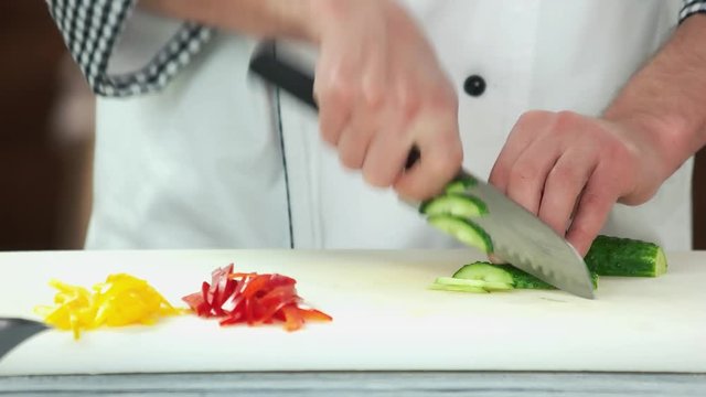 Hands cutting cucumber. Fresh green vegetable.