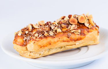 Appetizing sweet dessert. Cupcake with cream and nuts on light background