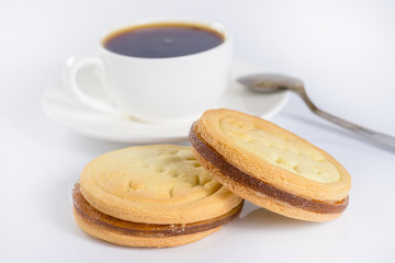 French sweet cookies and cup of coffee on light background
