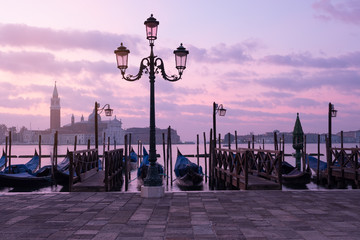 Venice classic sunrise view with gondolas on the waves