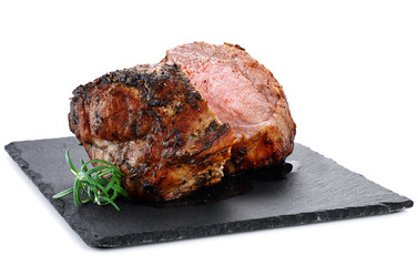 Baked pork meat and rosemary on the background of a slate board.