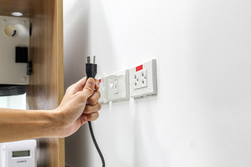 Hand are plugged in or unplugged electricity. Separated from a white background.
