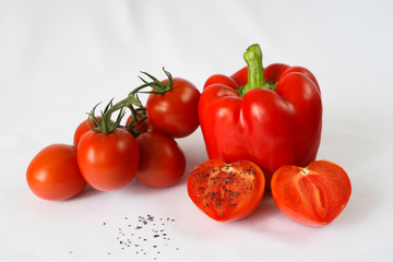 red bell pepper, red cherry tomatoes, black salt, white background