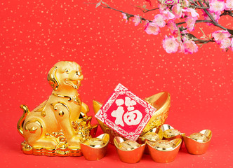 Chinese new year decoration:golden dog statue and gold ingots,translation of calligraphy: good Fortune for year