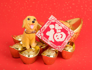 Chinese new year decoration:golden dog statue and gold ingots,translation of calligraphy: good Fortune for year