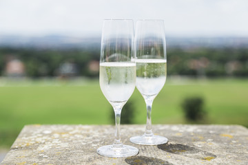 Two champagne glasses on stone with cityscape panorama