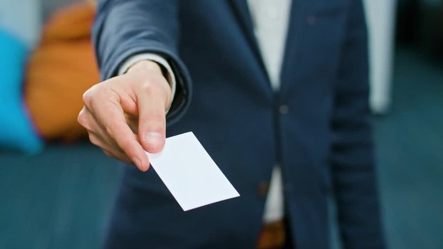 A businessman showing a blank piece of paper. Close-up shot. Soft focus.