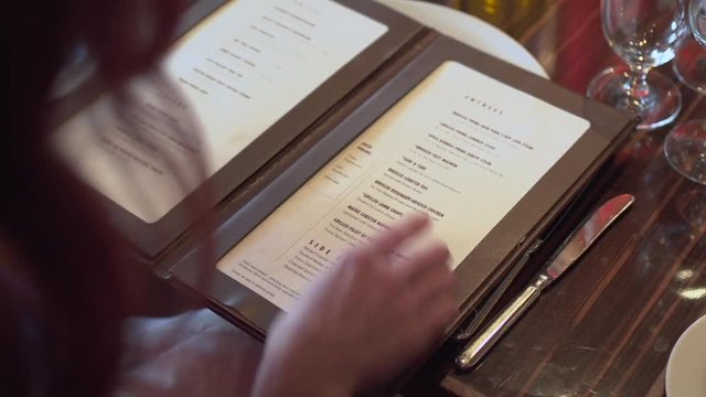 Woman pointing at a menu, choosing what to eat