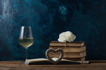 Open Book, Pen, Glass with Wine, Heart Handmade, Bud Rose on a Wooden Table