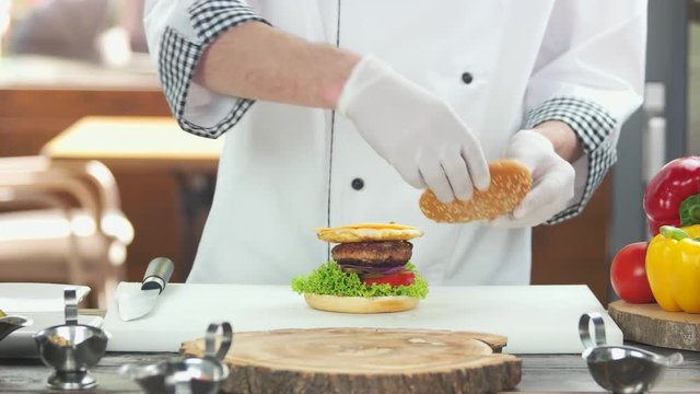 Chef making a tasty burger. Meat, egg and cheese.