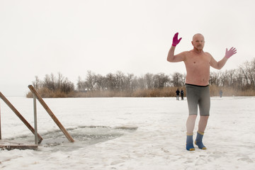 Crazy elderly Russian man, swimming in the ice-hole as President Putin on Lake Seliger. Feast of...