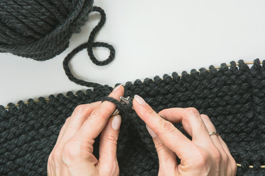 Close-up of hands knitting snud. Process of knitting.