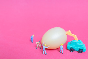Miniature people work at Easter-eggs for Easter day